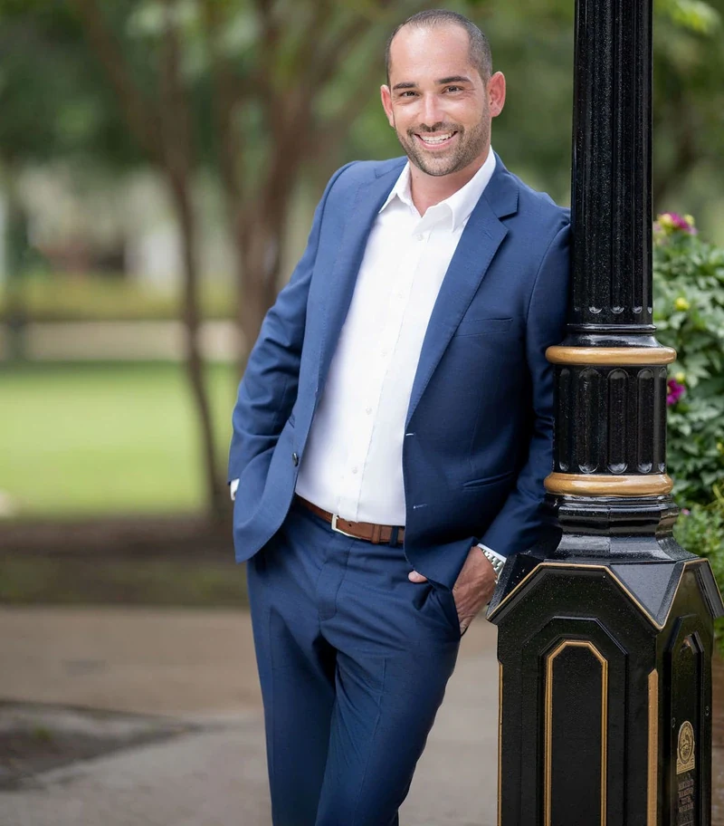 Justin McCarthy, Winter Park Realtor, standing beside a lamppost on Park Avenue